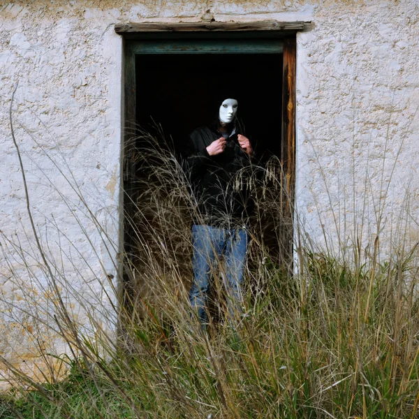 Figura mascarada e porta quebrada — Fotografia de Stock