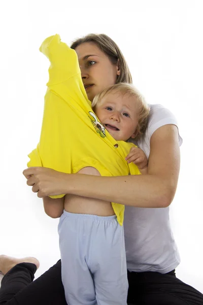 Sorgfältige Mutter kleidet den Sohn ein — Stockfoto
