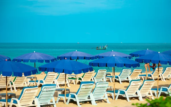Şezlong ve şemsiye ile kumlu plaj — Stok fotoğraf