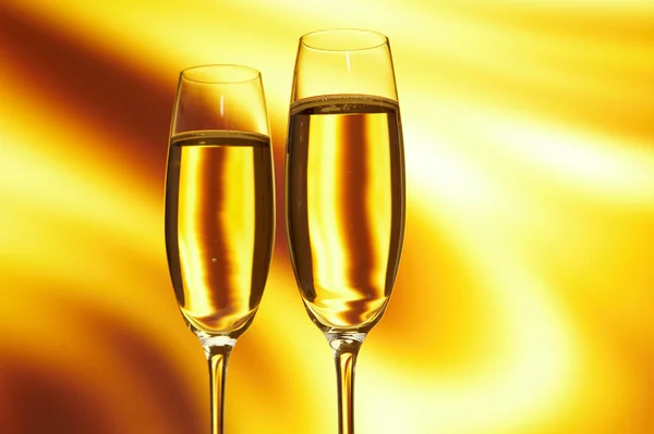 Glass of champagne against golden background — Stock Photo, Image