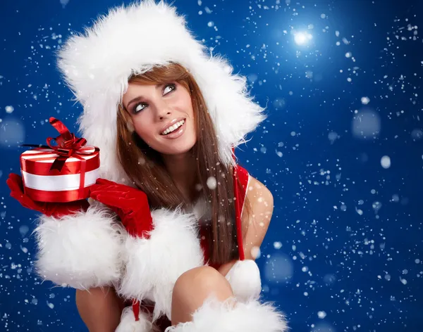 Vintern porträtt av en santa kvinna med en julklapp — Stockfoto