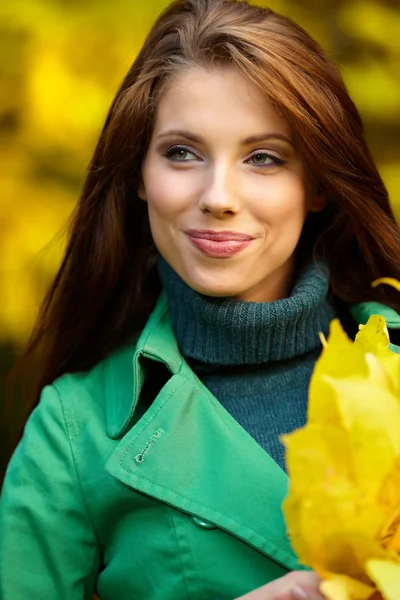 Mooie elegante vrouw in een park in de herfst — Stockfoto