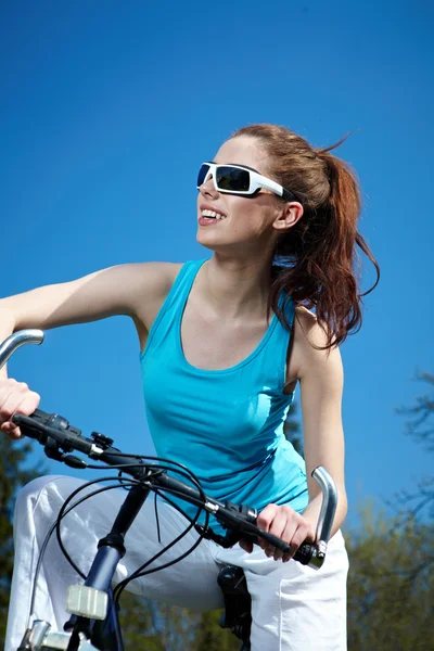 Young sexy woman on a bicykle outdoors smiling — Stock Photo, Image
