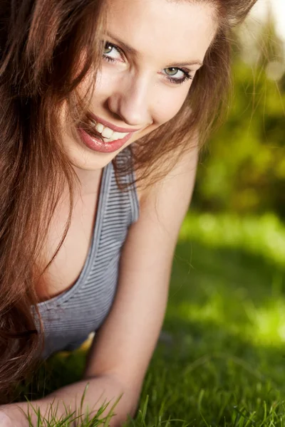 Sorridente bella donna sdraiata sull'erba — Foto Stock