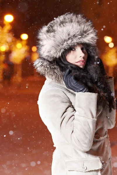 冬の夜の街で女性の笑みを浮かべて、雪の背景 — ストック写真
