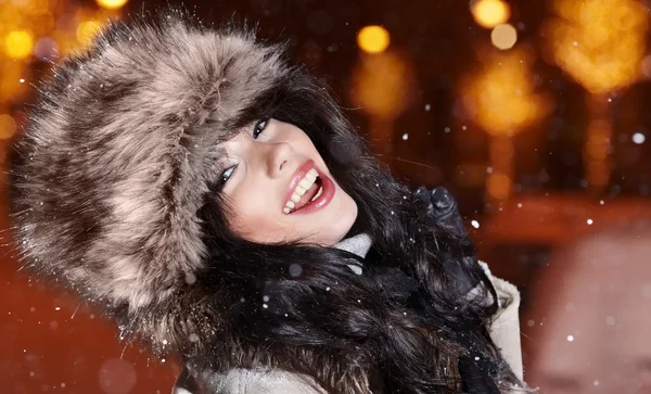 Mulher sorridente na cidade da noite de inverno, fundo de neve — Fotografia de Stock
