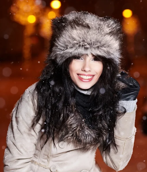 Χαμογελώντας γυναίκα στην πόλη νύχτα του χειμώνα, χιόνι υπόβαθρο — Φωτογραφία Αρχείου