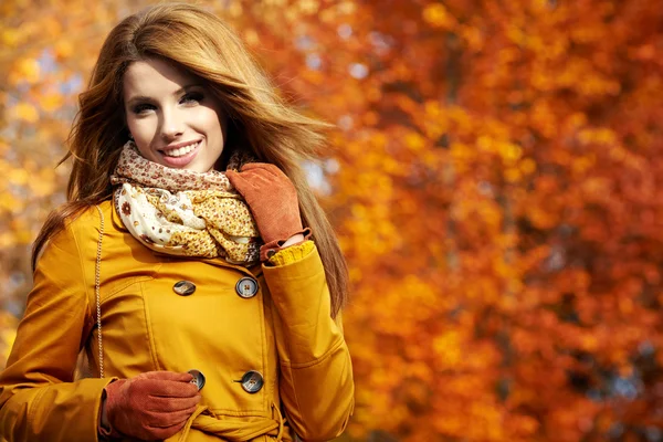 Retrato de una mujer de otoño acostada sobre hojas y sonriente — Foto de Stock