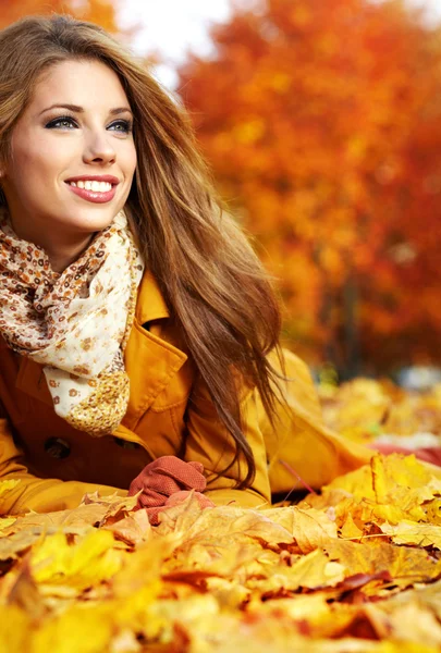 Портрет осінньої жінки, що лежить над листям і посміхається — стокове фото