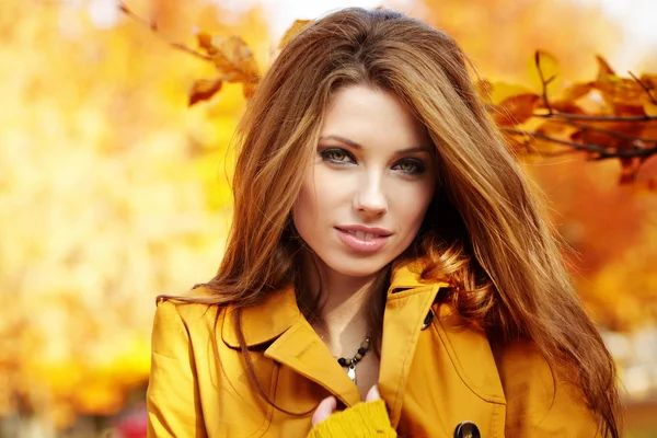Piękna elegancka kobieta stojąca jesienią w parku — Zdjęcie stockowe
