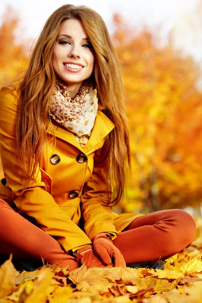 Πορτρέτο μιας φθινόπωρο γυναίκας που βρίσκεται πέρα από τα φύλλα και χαμογελαστός — Φωτογραφία Αρχείου