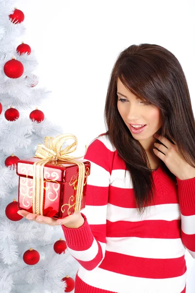 Όμορφη κοπέλα με δώρο κουτί δίπλα στο λευκό χριστουγεννιάτικο δέντρο — Φωτογραφία Αρχείου