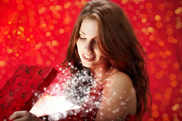 Sexy meisje glimlacht en het houden van een magisch cadeau in verpakking — Stockfoto