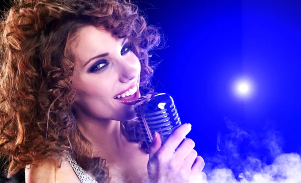 Retrato de uma menina glamourosa com microfone cantando canção — Fotografia de Stock