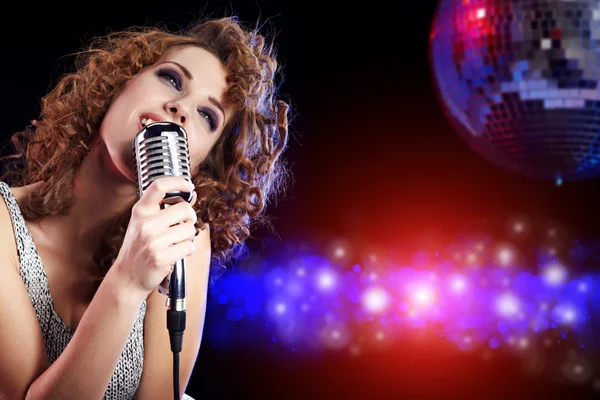 Portrait of a glamorous girl with mike singing song — Stock Photo, Image