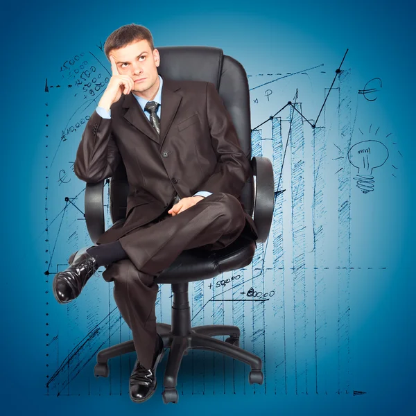 Geschäftsmann sitzt auf Stuhl vor Graphik-Hintergrund — Stockfoto