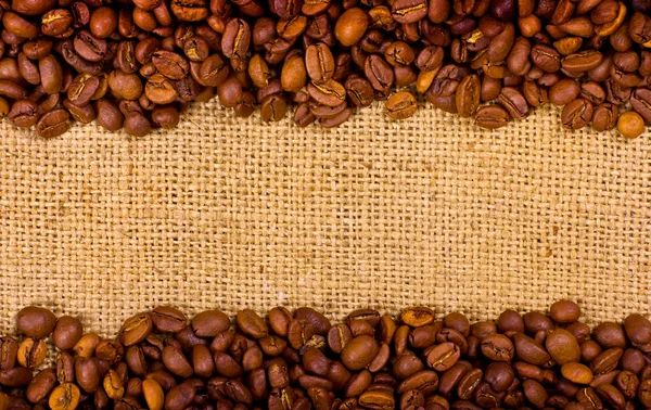 黄麻布の背景にコーヒーの穀物 — ストック写真