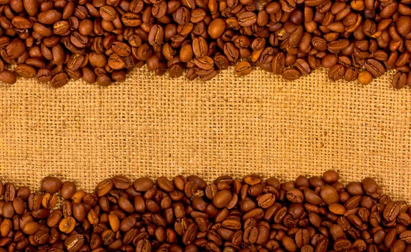 Granos de café en el fondo de arpillera —  Fotos de Stock