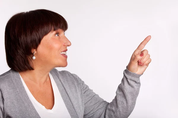 Середина жінка показує палець у напрямку — стокове фото