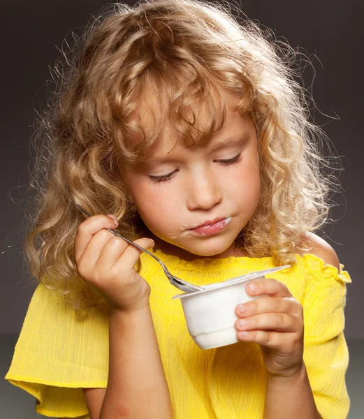 Dziewczynka je jogurt. — Zdjęcie stockowe