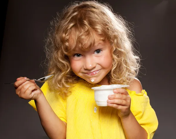 Little girl eating yogurt — Stock Photo, Image