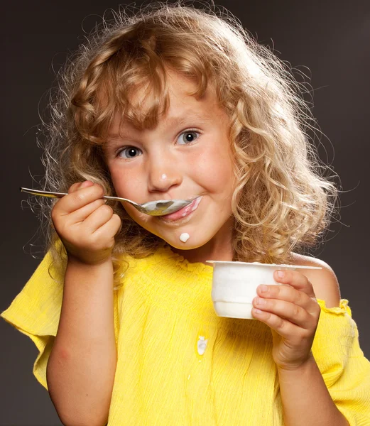 Niña comiendo yogur — Foto de Stock