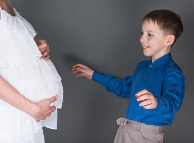 The boy looks at a stomach of pregnant mum clipart