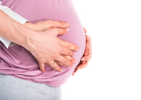 Мужские и женские руки держат живот беременной женщины — стоковое фото