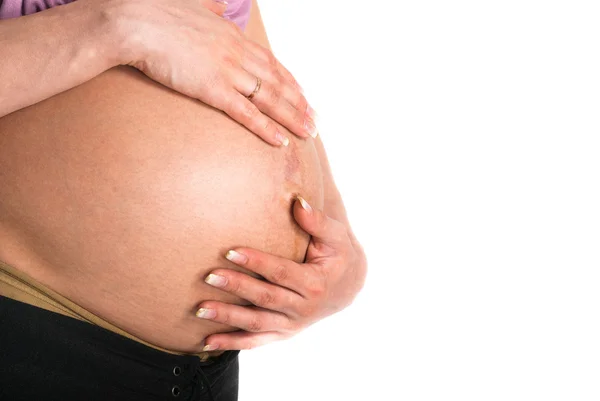 Estómago de la mujer embarazada sobre un fondo blanco —  Fotos de Stock