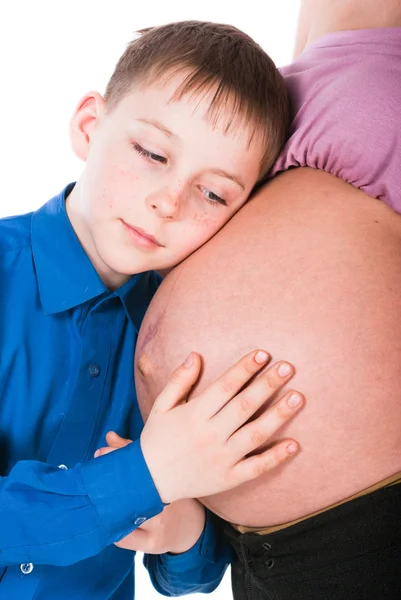 Le garçon écoute le ventre de sa mère enceinte — Photo