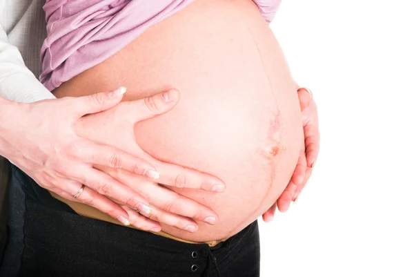 Hamile kadının göbek holding ve erkek eller — Stok fotoğraf