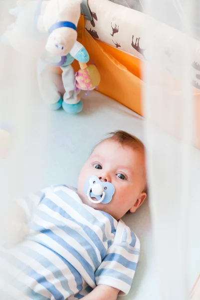 Stock image The small child in a bed