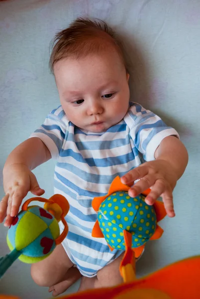 The baby plays to a bed — Stock Photo, Image