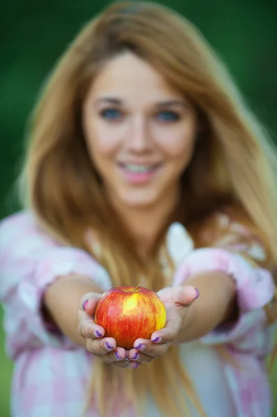 Junge Frau bietet roten Apfel an — Stockfoto