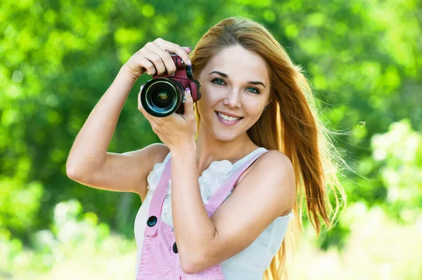 Beautiful woman holds camera — Stok fotoğraf