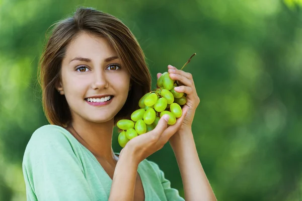 Hermosa mujer sosteniendo uvas — Foto de Stock