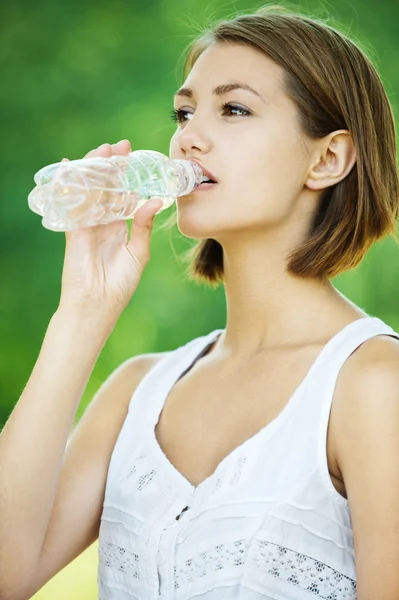 Молодая женщина пьет бутылку воды — стоковое фото