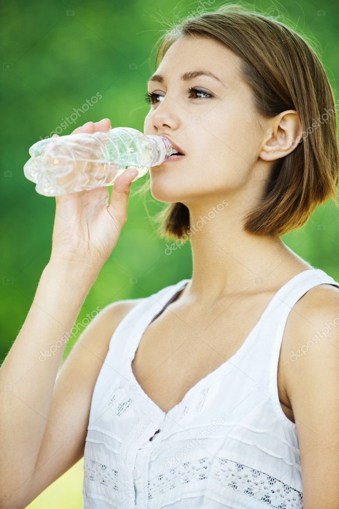 Young woman drinking water bottle