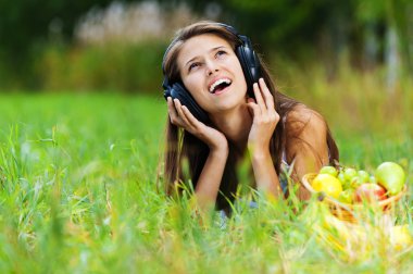 Young woman lying grass headphones fruit clipart