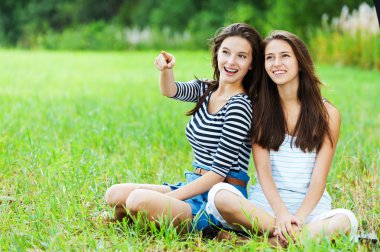 Two sisters sitting grass clipart