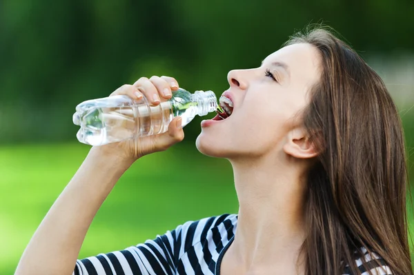 Young woman drinks water bottle — Stock Photo, Image