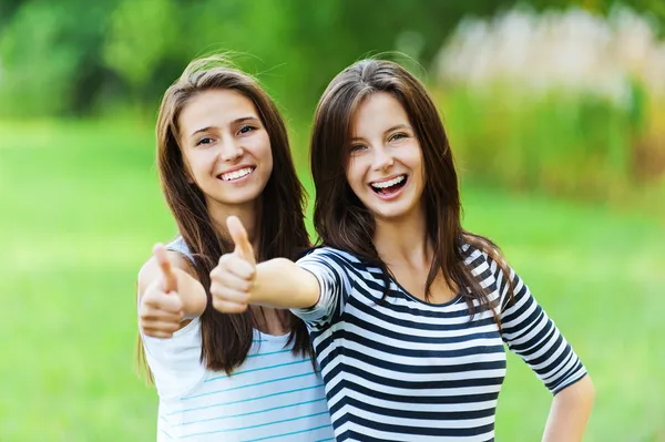 Duas mulheres sorrisos mão frente — Fotografia de Stock