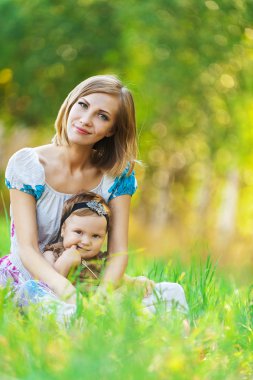 Mother daughter sitting grass clipart