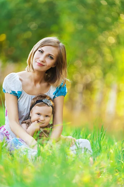 Mor dotter sitter gräs — Stockfoto