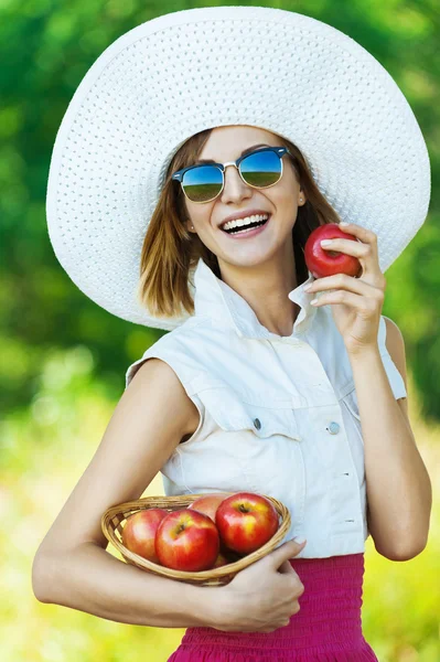 Kvinna solglasögon hatt äpplen — Stockfoto