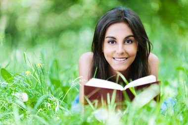 Young girl grass reading book clipart