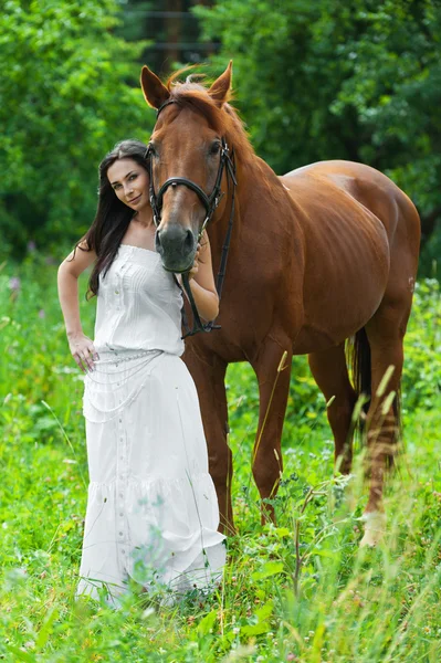 Jonge vrouw volgende paard — Stockfoto