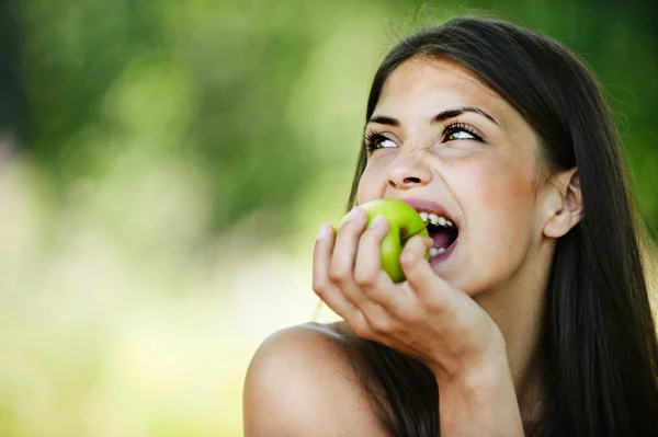 Porträt junge charmante Frau beißt in Apfel — Stockfoto