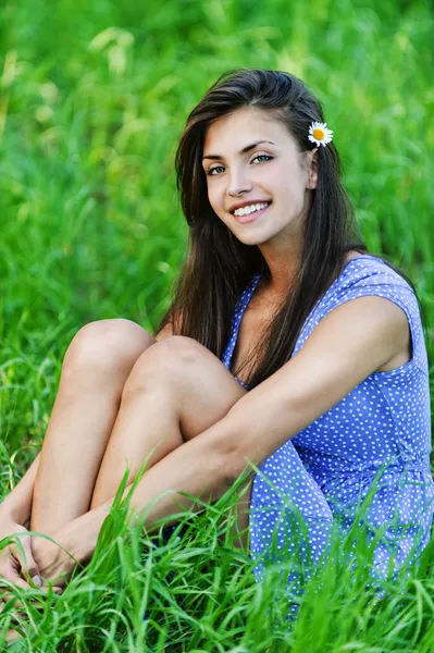 Bájos fiatal nő ül a zöld fű — Stock Fotó
