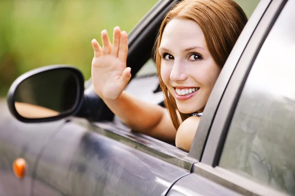 Pretty young woman sitting car looking out window — Stockfoto